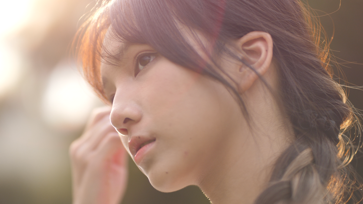 Girl with brown hair and sunlight behind