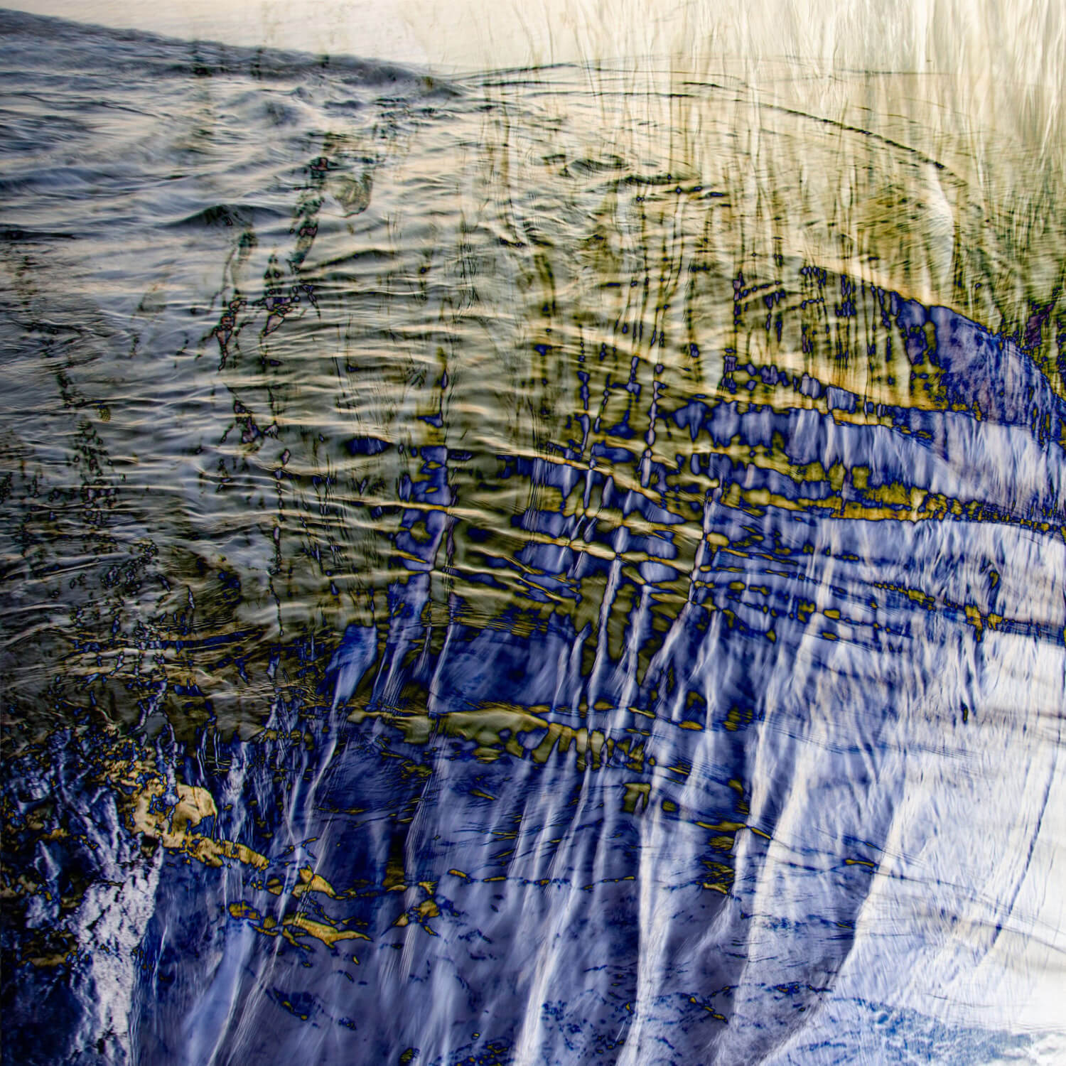 An abstract photograph combining the textures of flowing water with reflections of grass, creating a dynamic interplay of lines and colours.