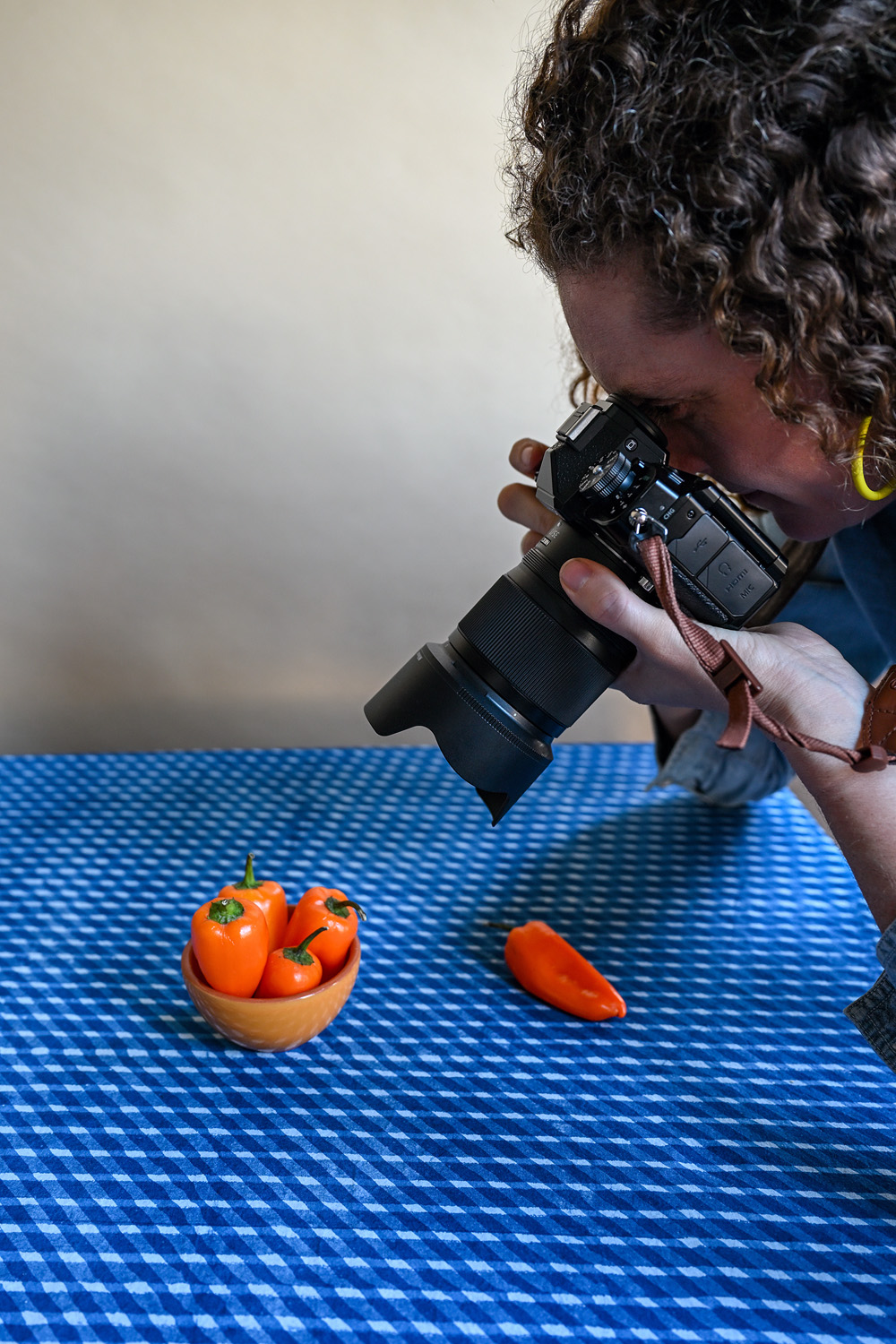 Woman taking close up photo of peppers with the Nikon Z 35mmf/1.4 lens