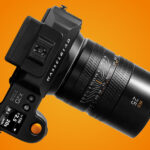 Image of Hasselblad XCD 2,5/25V lens attached to X2D 100C camera on an orange background